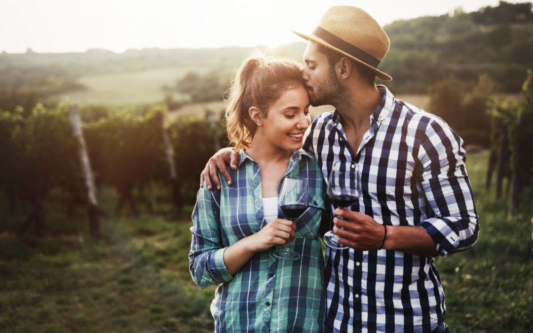 couple in vineyard with wine glasses